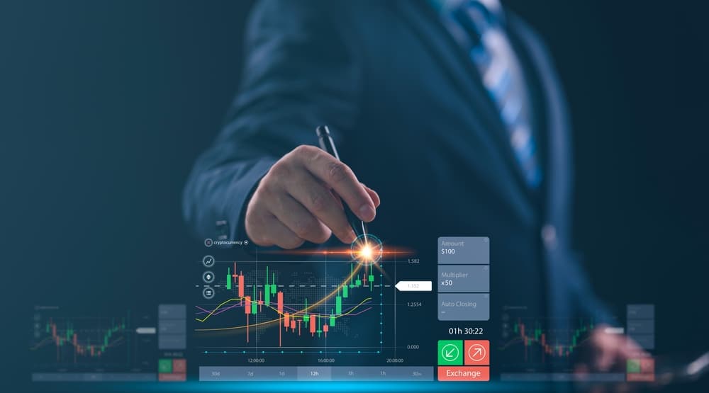 Businessperson in a suit interacts with a holographic stock chart showing candlesticks and indicators.